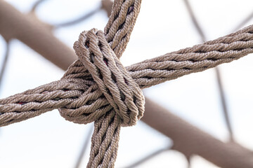 Close-up of rope knot line tied together with playground background