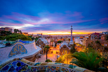 Naklejka premium Beautiful sunrise in Barcelona seen from Park Guell. Park was built from 1900 to 1914 and was officially opened as a public park in 1926. In 1984, UNESCO declared the park a World Heritage Site