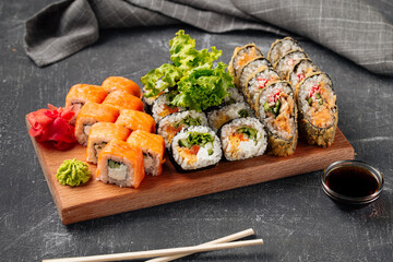 Side view on sushi roll assorted set on the wooden board with soy sauce