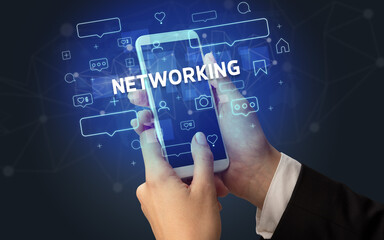Female hand typing on smartphone with NETWORKING inscription, social media concept