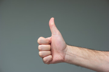 Caucasian male hand doing the OK great affirmation gesture close shot isolated on gray