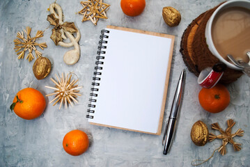 Christmas background. Blank notebook for planning, Christmas decorations, coffee with milk on a gray background, top view