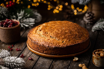 Obraz na płótnie Canvas Traditional Christmas cake pudding with fruits and nuts with Christmas decorations, dark background