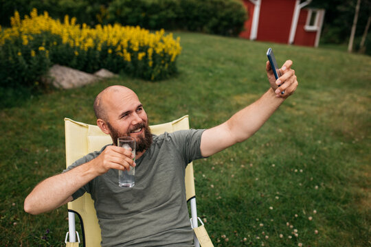 Man on deck chair taking selfie