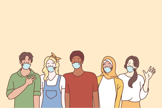 Coronavirus disease and multi ethnic youth friends concept. Group of young people teens students wearing face medical masks for preventing corona virus outbreak standing showing signs waving hands