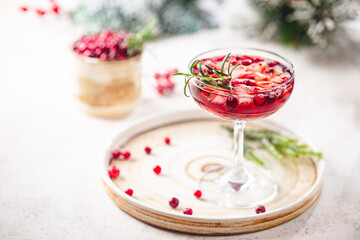 Refreshing drink with cranberries and rosemary on white background