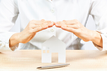 Businesswoman with white shirt protecting the house with his hands