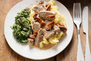 Pork loin with sun dried tomatoes in cream sauce with mashed potatoes and spinach  - 398741552