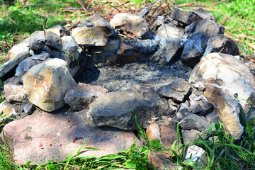 Fire prevention in a forest, capmfire safety: a properly built campfire, hearth with a fireguard, a firepit surrounded by rocks and stones.