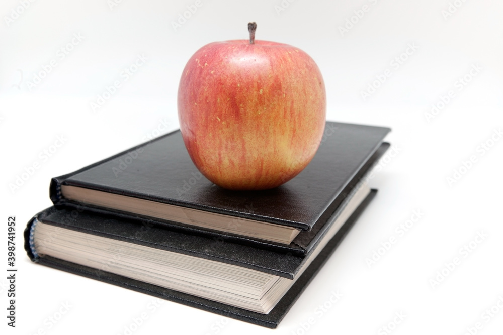 Wall mural red apple on notebooks isolated on white background