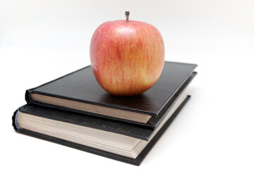 Red apple on notebooks isolated on white background