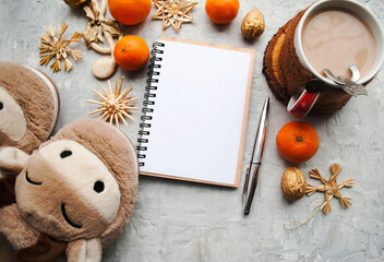 Beautiful Christmas background. Blank notebook for planning, Christmas decorations, coffee with milk on a gray background, top view. Year of the bull, 2021.