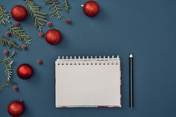 New Year's decor and a notebook in the center on a blue background. Christmas decoration. Copy space, flat lay, mock up, top view.