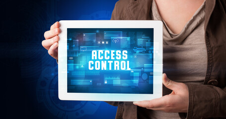 Young business person working on tablet and shows the digital sign: ACCESS CONTROL