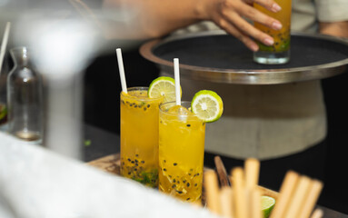 Close up hand of server at the bar carry cocktails on the round tray