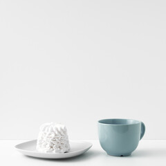 Mug and meringue cake on a white background. Eco-friendly and natural materials in decor and interior design, dessert. Copy space, mock up