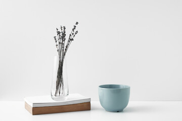 Mug and transparent vase with flowers on a white background. Eco-friendly materials in the decor of the room, minimalism. Copy space, mock up.