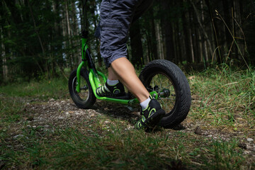 riding a skate scooter in forest © Antirejas