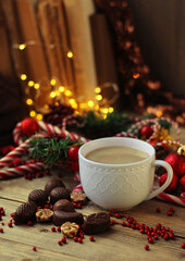 Obraz na płótnie Canvas Chocolate candies, Coffee cup, candle, Christmas decor. Christmas and New Year Holiday concept. festive winter season. home hugge atmosphere
