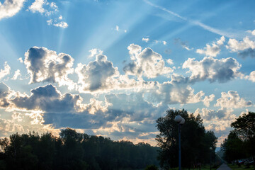 Obraz premium Bright sunset on the background of cloudy sky and forest.