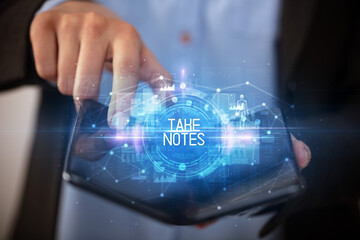 Young man holding a foldable smartphone with TAKE NOTES inscription, educational concept