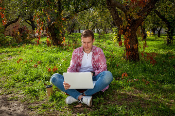 Guy working on laptop in the park