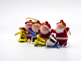three funny santa claus toys with christmas bells on white background. In focus and out of focus