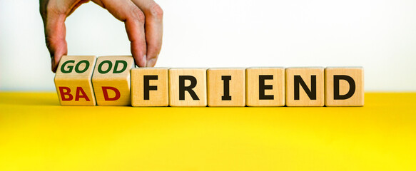 Good or bad friend symbol. Male hand turns wooden cubes and changes words 'Bad friend' to 'Good...