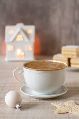 Christmas morning table with a cup of cappuccino and festive cake in a background