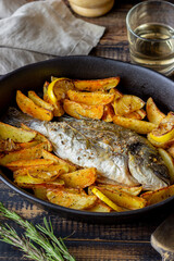 Dorado or sea bream baked with potatoes and lemon. Healthy eating. Diet.