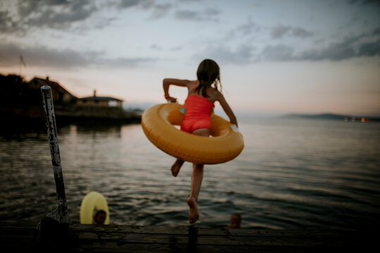 Girl with inflatable ring jumping into water