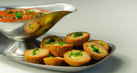 Mini scotch eggs with tomato sauce served on the silver plate
