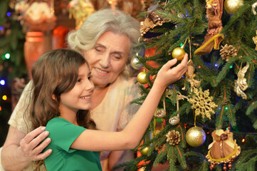 Smiling little girl with grandmother on Christmas