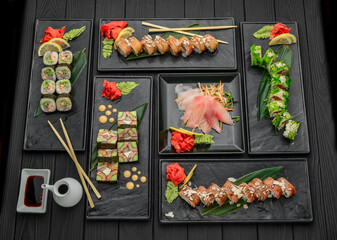 Fresh and delicious sushi set on black background