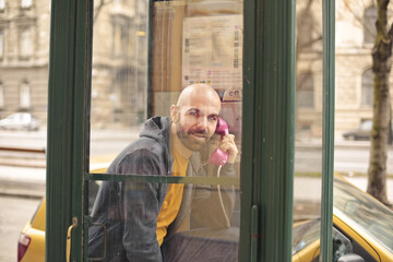 man speaks in a telephone booth