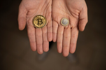 Caucasian hands shows one Bitcoin coin and one Euro Coin. New finance concept. Comparison between currencies, fiat and crypto. Two hands