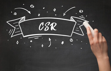 Hand drawing CSR abbreviation with white chalk on blackboard