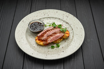 Juicy duck breast steaks with caramelized apple on plate. Hot Meat Dishes