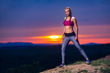 Determined Athletic Fitness Woman in Pose after Running on Hills at Sunset