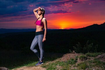 Determined Athletic Fitness Woman Catching a Breath after Running on Hills at Sunset