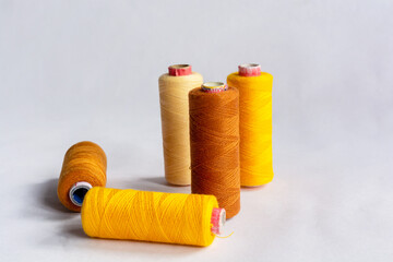 Five sewing thread spools on isolated white background.