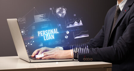 Businessman working on laptop with PERSONAL LOAN inscription, new business concept