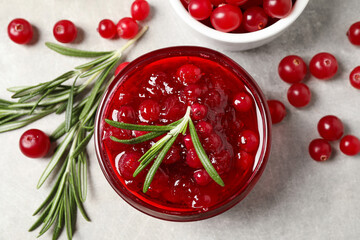 Cranberry sauce, rosemary and fresh berries on light table, flat lay