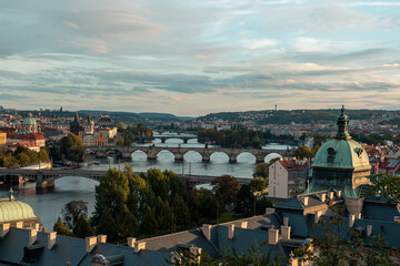 .view of prague at sunset on the vltava river and bridges on it and roofs of old buildings in the center of prague in czech republic