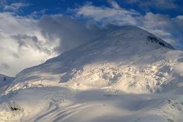 Snow peak in the clouds. Semenov Peak (5816 m), Central Tian Shan, Kyrgyzstan.