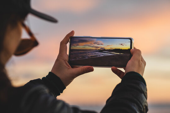 Chica Toma Una Fotografia De Una Playa Al Atardecer