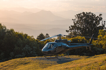 helicopter at sunset with mountains in background
