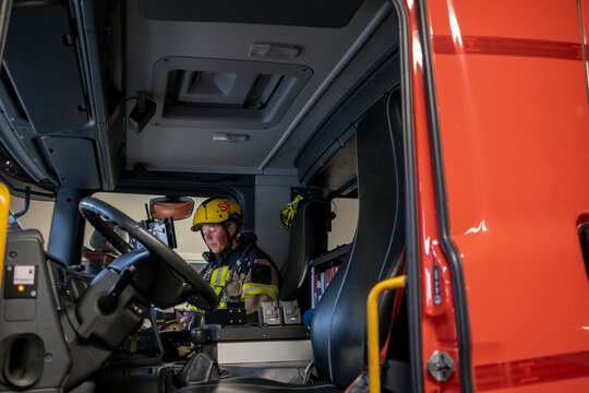Female firefighter sitting in fire engine