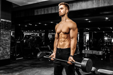 Fototapeta na wymiar muscular bodybuilder doing heavy deadlift with a barbell in a modern gym