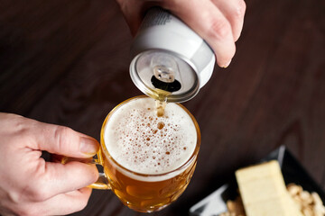 Canned beer puring into mug, light wheat beer